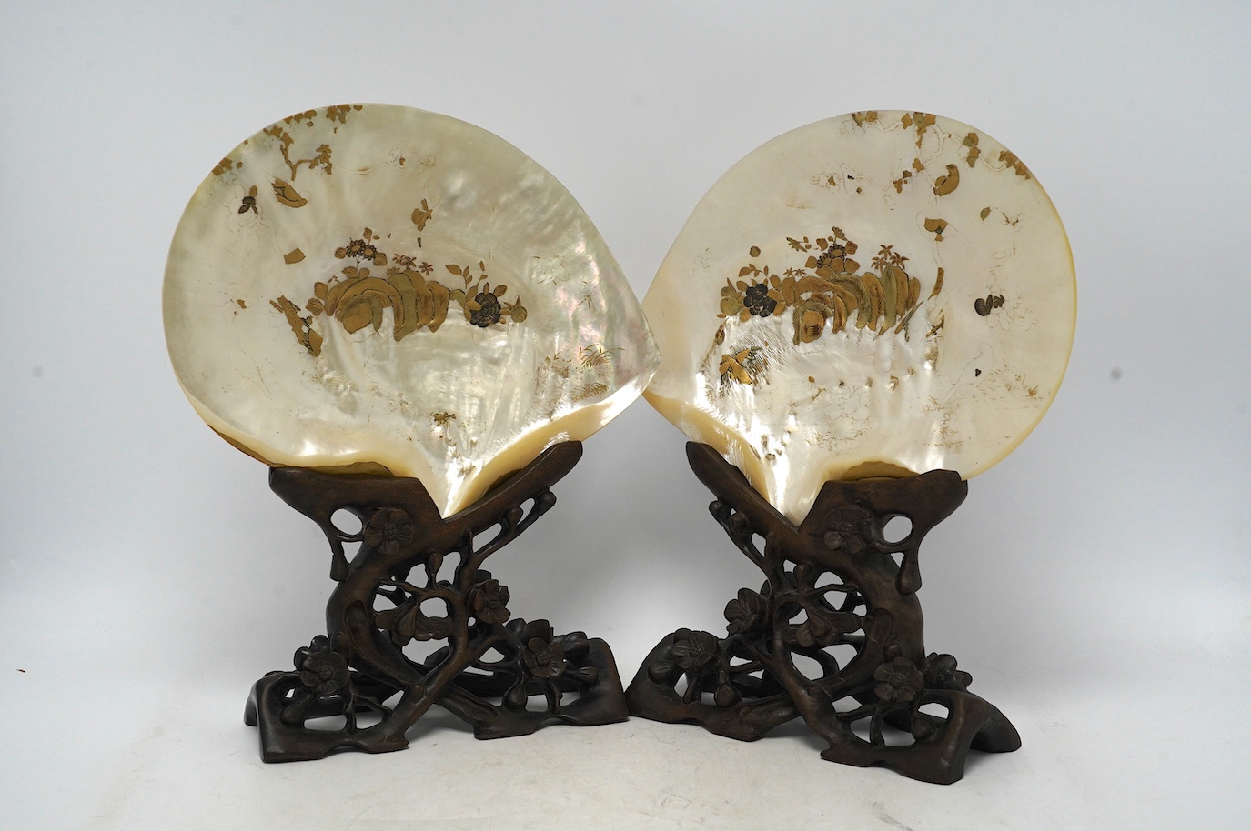 A pair of Japanese gold lacquer mother-of-pearl shells on Chinese hongmu stands, late 19th century, shells 25cm wide. Condition - fair to good
